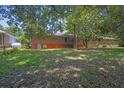 Spacious backyard with mature trees offering ample shade, partially fenced with a brick foundation at 2261 Star Mist Sw Dr, Atlanta, GA 30311