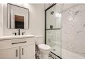Modern bathroom with a glass shower, white vanity, and unique tile flooring at 290 Bromack Se Dr, Atlanta, GA 30315