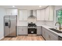 Bright kitchen features stainless steel appliances and two-tone cabinets against wood flooring at 290 Bromack Se Dr, Atlanta, GA 30315