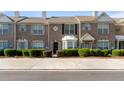 Close-up of a two-story brick townhome with manicured landscaping and an individual entrance at 2727 Parkway Trl, Lithonia, GA 30058