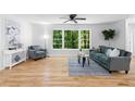 Sunlit living room with hardwood floors and a large window with views of lush greenery at 2984 E Paulding Dr, Dallas, GA 30157