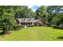 Beautiful brick home on a lush green lawn surrounded by mature trees at 7376 Bates Dr, Cumming, GA 30040