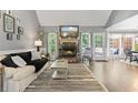 Inviting living room with fireplace, hardwood floors, and bright natural light at 7376 Bates Dr, Cumming, GA 30040