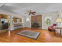 Cozy living room featuring a brick fireplace, hardwood floors, and abundant natural light at 8415 Ridge Rd, Fairburn, GA 30213