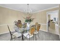 Charming dining area with a glass table, chandelier, and adjacent view into kitchen and entry at 985 Laurel Springs Ln, Marietta, GA 30064