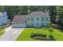 Stunning two-story home featuring a three-car garage, well-manicured lawn, and a charming, symmetrical facade at 985 Laurel Springs Ln, Marietta, GA 30064