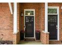 Charming brick townhome entrance featuring black doors, white trim, and potted pink flowers for added curb appeal at 1258 Dekalb Ne Ave # 112, Atlanta, GA 30307