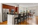 Light-filled kitchen with stainless steel appliances, dark wood cabinets, countertop dining, and eat-in dining area at 1258 Dekalb Ne Ave # 112, Atlanta, GA 30307