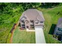 Aerial view of a well-maintained home with a large yard, mature trees, and a long driveway at 4931 Pauls Pointe, Sugar Hill, GA 30518
