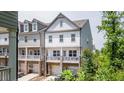 Townhouse exterior featuring white siding, stone accents, and a charming porch, ideal for outdoor relaxation and curb appeal at 2106 Remy Ct, Kennesaw, GA 30144