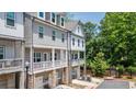 Three-story townhouse row featuring stone and siding, with cozy covered porches on the main level, perfect for relaxation at 2106 Remy Ct, Kennesaw, GA 30144