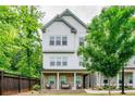 Charming townhouse with white siding and a stone-accented porch, complemented by lush greenery for a serene setting at 2106 Remy Ct, Kennesaw, GA 30144