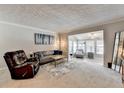 Comfortable living room featuring plush seating, a stylish coffee table, and abundant natural light from the adjacent sunroom at 5149 Roswell Rd # 7, Atlanta, GA 30342