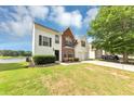 Charming two-story home featuring a brick facade, white siding, a two-car garage, and water view at 11827 Spring Lake Way, Fayetteville, GA 30215
