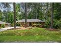 Brick home with mature trees, green lawn, and carport on a sunny day at 1376 Woodbine St, Marietta, GA 30062
