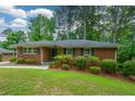 Well-kept brick home featuring neat landscaping and dark shutters, presenting a welcoming curb appeal at 1376 Woodbine St, Marietta, GA 30062
