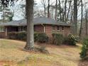 This brick home offers a serene landscape with mature trees and manicured greenery at 1376 Woodbine St, Marietta, GA 30062