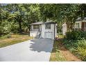 Attractive home with a long driveway and lush greenery, shaded by mature trees offering both curb appeal and privacy at 2537 Baker Nw Rd, Atlanta, GA 30318