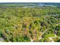 Expansive aerial view of a lush, wooded neighborhood with lake glimpses at 5345 Pilgrim Point Rd, Cumming, GA 30041