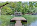 Beautiful lake view featuring a private dock with boat lift and serene water at 5345 Pilgrim Point Rd, Cumming, GA 30041