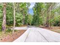 Long, paved driveway leading through a wooded area to the property at 5345 Pilgrim Point Rd, Cumming, GA 30041