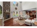 Open-concept living room with a stone fireplace, hardwood floors, and views of the backyard at 237 Parc Drive Dr, Canton, GA 30114