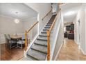 Inviting foyer showcasing staircase alongside dining room and tile flooring at 140 Melrose Creek Dr, Stockbridge, GA 30281