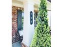 Close-up of the front porch featuring a column, house number, and an evergreen shrub at 724 Laura Jean Ct, Buford, GA 30518