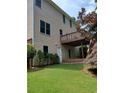 Back of house with wooden deck and stairs, complemented by lush green lawn at 4217 Mill Grove Sw Ln, Smyrna, GA 30082