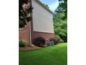 Exterior side view of the home, featuring brick accents and mature landscaping at 4217 Mill Grove Sw Ln, Smyrna, GA 30082