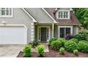 A close-up of the front door, landscaping, and attached garage at 8895 Club River Dr, Roswell, GA 30076