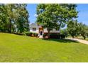 Traditional style home with manicured green lawn, mature trees, and welcoming front entrance with charming brick details at 5077 Fieldview Dr, Douglasville, GA 30135