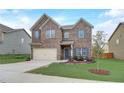 Two-story brick home with an attached two-car garage with a manicured lawn and small tree at 1173 Gaines St, Jonesboro, GA 30238