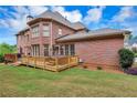 Spacious wooden deck with railings and stairs, with an adjacent hot tub at 3332 Heathchase Ln, Suwanee, GA 30024