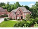 A stately brick home with manicured lawn, lush shrubs, and a charming fountain feature at 3332 Heathchase Ln, Suwanee, GA 30024