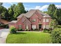 Beautiful brick home featuring a well-manicured lawn, mature landscaping, and charming curb appeal at 3332 Heathchase Ln, Suwanee, GA 30024
