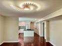Open-concept kitchen with a large island, white cabinets, and modern lighting fixture above at 415 Wood Trace Ct, Alpharetta, GA 30022