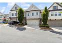 Attractive townhome facade with a two-car garage, complemented by lush green landscaping at 1241 Hightower Nw Xing, Marietta, GA 30060