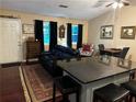 Open-concept living room with hardwood floors, black leather sofa, and island seating at 3474 Leaf Land Ct, Duluth, GA 30097