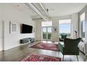 Inviting living room featuring large windows, a television, stylish seating, and access to a balcony with a view at 3820 Roswell Ne Rd # 510, Atlanta, GA 30342