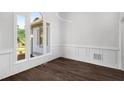 Dining room features dark floors, detailed wall trim, and large windows for natural light at 7025 Bavarian Wood Pl, Buford, GA 30518