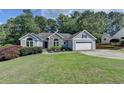 Beautifully landscaped home with two-car garage, manicured lawn, and stone facade at 1882 Flowering Dr, Grayson, GA 30017