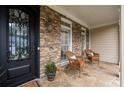 Cozy front porch featuring stone accents, decorative chairs, and an elegant front door at 5440 Old Haven Ct, Cumming, GA 30041