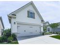 Angle showing the two-car garage of this home with white siding and stone veneer at 603 Canyon Overlook, Canton, GA 30114