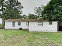 The backyard is spacious with a large grassy area and a simple white exterior at 908 Kennesaw Dr, Forest Park, GA 30297