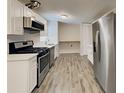 Modern kitchen featuring stainless steel appliances, white cabinetry, and sleek countertops at 908 Kennesaw Dr, Forest Park, GA 30297