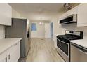 Bright kitchen with stainless steel appliances, white countertops, and light wood-look flooring at 908 Kennesaw Dr, Forest Park, GA 30297