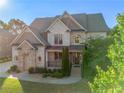 Charming two-story brick house featuring a covered porch and beautifully landscaped front yard at 2604 Heltonwood Ct, Buford, GA 30519