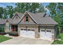 Charming stone and siding home with well-manicured lawn and a three-car garage at 295 Hanover Dr, Villa Rica, GA 30180