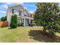 Charming two-story brick home with a well-manicured lawn and a large tree in the front yard at 507 Vaughan Dr, Hampton, GA 30228